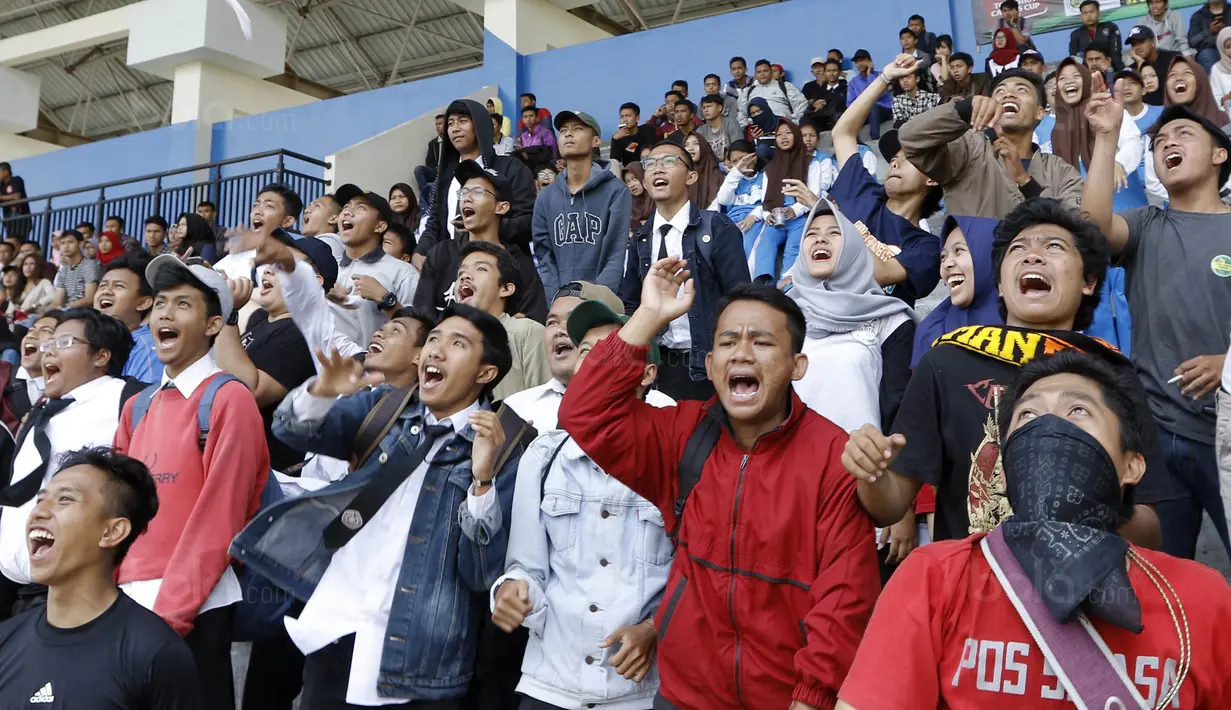 Ekspresi suporter Universitas Muhammadiyah Malang (UMM) saat memberikan dukungan pada laga final Torabika Campus Cup 2017 di Stadion UM, Malang, Kamis, (02/11/2017). UMM menang 2-0 atas UM. (Bola.com/M Iqbal Ichsan)