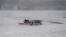 Kendaraan pembersih salju beroperasi di Bandara Ataturk, Istanbul, untuk mengurangi tumpukan salju tebal, Sabtu (7/1). Badai salju menyebabkan jarak pandang yang pendek bagi penerbangan dan membawa angin kencang. (OZAN KOSE/AFP)