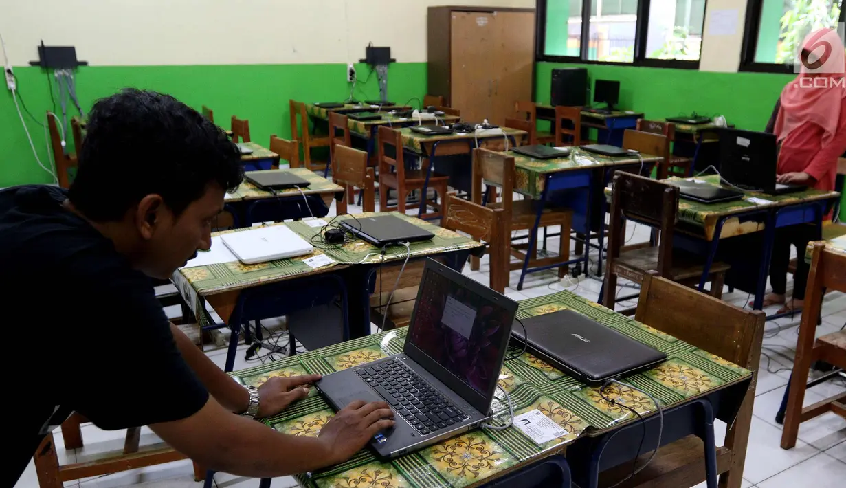 Petugas mengecek kesiapan laptop dan ruang untuk Ujian Nasional Berbasis Komputer di SMP N 34 Pademangan, Jakarta Utara, Minggu (22/4). UNBK SMP 2018 akan berlangsung mulai besok Senin (23/4). (Liputan6.com/Johan Tallo)