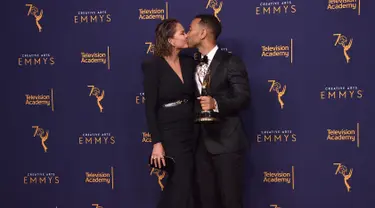 Chrissy Teigen dan John Legend berciuman di karpet merah selama Creative Arts Emmy 2018 di Microsoft Theater di Los Angeles, California, AS (9/9). John Legend mendapatkan penghargaan di acara tersebut. (AFP Photo/Alberto E. Rodriguez)