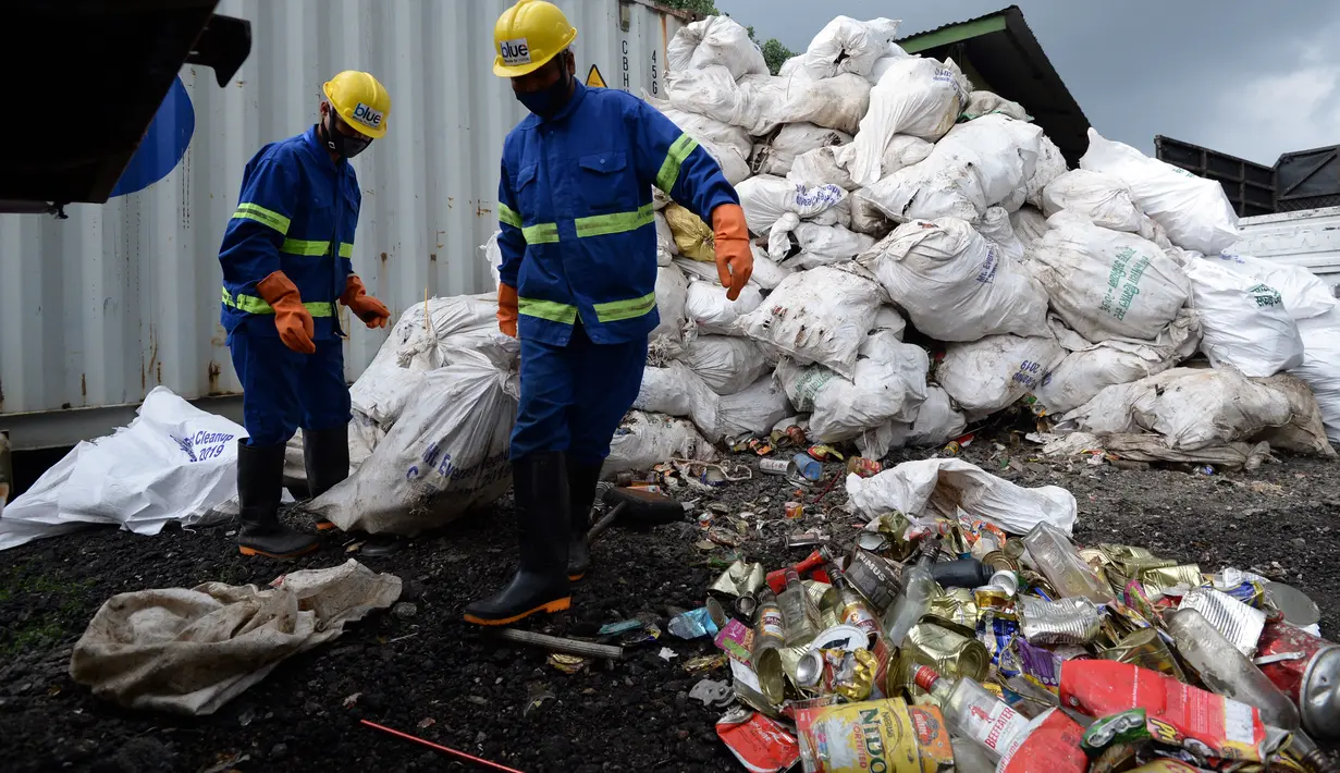 Pekerja perusahaan daur ulang membuka karung berisi sampah dari Gunung Everest di Kathmandu, 5 Juni 2019.  Ekspedisi pemerintah Nepal selama 45 hari mengumpulkan pembungkus makanan, kaleng, botol, tabung oksigen kosong dan limbah lainnya dari gunung setinggi 8.850 meter. (PRAKASH MATHEMA/AFP)