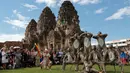 Penari dengan kostum monyet menari di hadapan wisatawan selama Festival Monkey Buffet, kuil Phra Prang Sam Yot, Bangkok, Thailand (27/11). (REUTERS/Chaiwat Subprasom)