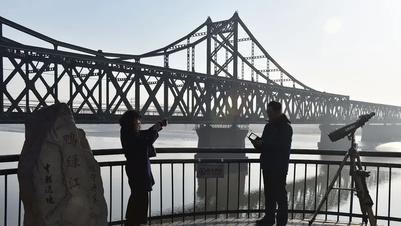 Turis mengambil foto  Turis mengambil foto di Jembatan Perbatasan Sungai Yalu, yang memisahkan China dan Korut (AFP/Greg Baker)