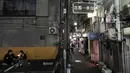 Suami-istri merokok di tempat parkir yang berdekatan dengan Golden Gai di distrik Shinjuku, Tokyo (28/7/2019). Shinjuku Golden Gai adalah daerah kecil di Kabukicho, Shinjuku, Tokyo, Jepang, yang terkenal baik sebagai bidang minat arsitektur dan kehidupan malamnya. (AFP Photo/Jae C. Hong)