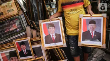 Pedagang membawa bingkai foto Presiden Joko Widodo dan Wakil Presiden terpilih Ma'ruf Amin yang dijualnya di Pasar Baru, Jakarta, Rabu (16/10/2019). Menjelang pelantikan presiden, foto pasangan Jokowi-Ma'ruf Amin mulaih dijual ke pasar umum. (Liputan6.com/Faizal Fanani)