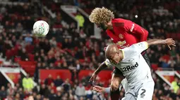 Pemain Manchester United (MU), Marouane Fellaini menyundul bola ke gawang Derby County saat laga Piala Liga Inggris di Old Trafford, Manchester, Inggris, Selasa (25/9). MU kalah dari Derby County lewat adu penalti. (Martin Rickett/PA via AP)