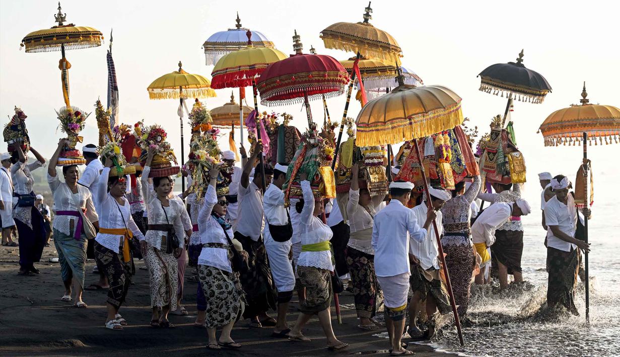 Umat Hindu saat mengikuti upacara doa Melasti di salah satu pantai di Denpasar, Bali, pada Senin 16 Maret 2026. Rangkaian upacara menyambut Hari Raya Nyepi Tahun Baru Saka 1948 di sejumlah wilayah di pulau Bali mulai dilaksanakan dengan prosesi melasti di sejumlah pantai dan sumber mata air. (SONNY TUMBELAKA/AFP)