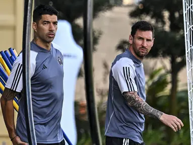 Pemain baru Inter Miami, Luis Suarez (kiri) bersama Lionel Messi mendatangi latihan pramusim Inter Miami di Florida Blue Training Center, dekat DRV PNK Stadium, Florida, Fort Lauderdale, Sabtu (13/01/2024) waktu setempat. (AFP/Chandan Khanna)