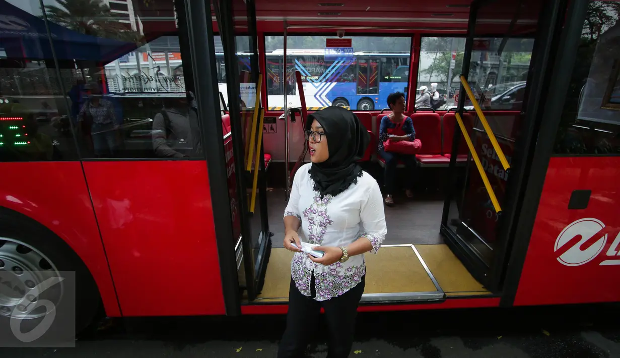 Seorang petugas bus tingkat wisata TransJakarta mengenakan kebaya saat menjalankan tugasnya di Jakarta, Jumat (21/4). Dalam rangka Hari Kartini, semua pramudi perempuan bus pariwisata dan Transjakarta mengenakan kebaya. (Liputan6.com/Faizal Fanani)