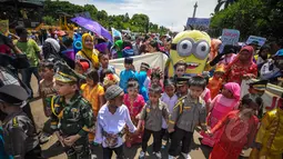 Sejumlah anak kecil yang mengenakan pakaian adat tradisional dan seragam TNI Polri ikut meramaikan aksi Karnaval Rakyat Lawan Korupsi dari patung kuda menuju Istana Negara, Jakarta, Rabu (8/4/2015). (Liputan6.com/Faizal Fanani)