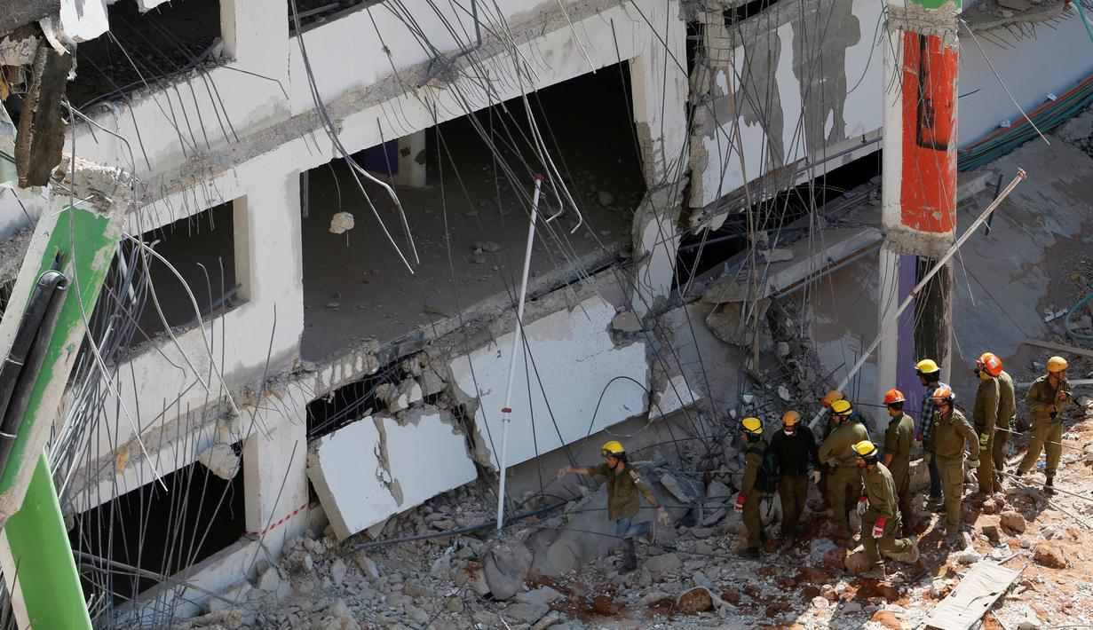 Petugas regu penyelamat dikerahkan mencari warga yang hilang di reruntuhan gedung parkir yang ambruk di Tel Aviv, Israel, Senin (5/9). Dua orang tewas dan lainnya hilang akibat ambruknya gedung parkir yang sedang dibangun tersebut. (REUTERS/Nir Elias)