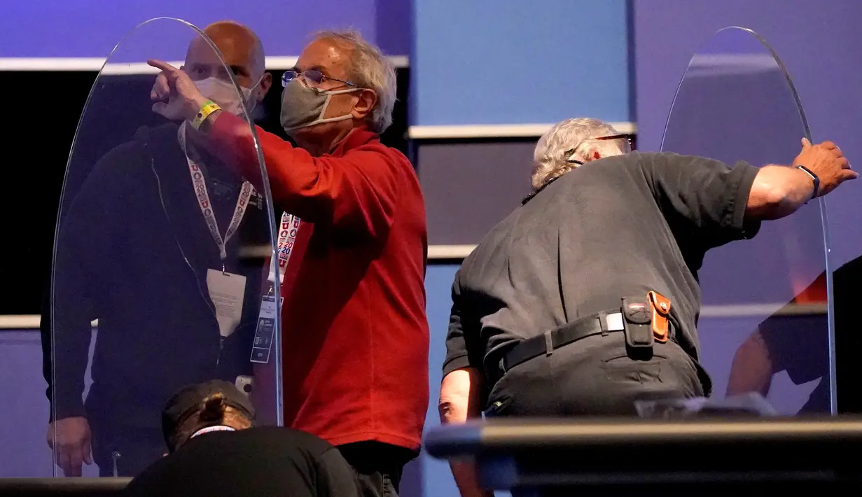 Tim produksi memeriksa panel plastik pelindung di atas panggung di antara meja untuk Wakil Presiden Mike Pence dan penantangnya, Kamala Harris, saat persiapan untuk debat cawapres di Universitas Utah, Salt Lake City, Selasa (6/10/2020). (AP Photo/Julio Cortez)