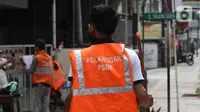 Warga pelanggar PSBB dihukum menyapu saat terjaring razia masker di Jalan Tanjung Duren Raya, Jakarta, Jumat (11/9/2020). Petugas Satpol PP gencar melakukan razia masker menyusul kasus COVID-19 di DKI Jakarta yang terus meningkat. (merdeka.com/Imam Buhori)