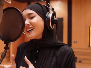 Dalam unggahan foto saat melakukan rekaman lagu, Cita Citata terlihat tampil dalam balutan hijab pasmina berwarna hitam. Penampilan wanita 28 tahun ini pun menjadi sorotan netizen. (Liputan6.com/IG/@cita_citata)