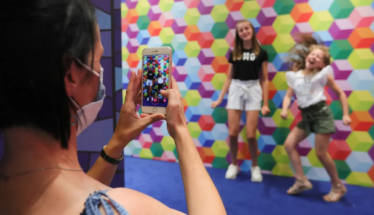 Seorang wanita merekam video dua anak perempuan menggunakan aplikasi TikTok di Smile Safari, sebuah museum Instagram dan TikTok, di Brussel, Belgia (7/8/2020). (Xinhua/Zheng Huansong)