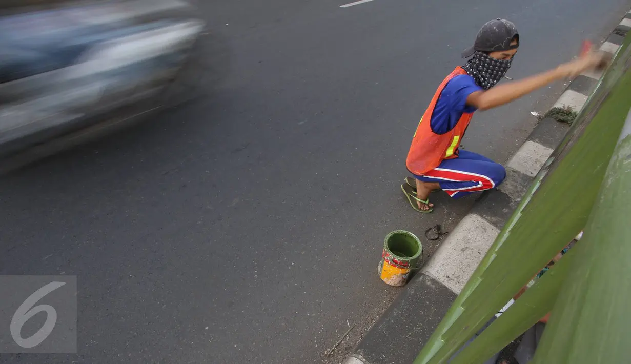 Pekerja mengecat pagar pembatas jalan di kawasan Pasar Minggu, Jakarta Selatan, Rabu (26/10). Pengecatan dilakukan sebagai bentuk perawatan agar pagar pembatas tetap rapi dan tidak tampak kusam. (Liputan6.com/Immanuel Antonius)