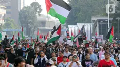 Sejumlah peserta aksi mengikuti aksi gerakan Global March to Gaza menuju kawasan Bundaran Hotel Indonesia, jalan MH Thamrin, Jakarta, Minggu (15/6/2025). (Liputan6.com/Herman Zakharia)