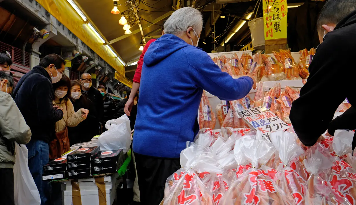 Pengunjung membeli makanan dan perlengkapan untuk merayakan Tahun Baru di distrik perbelanjaan Ueno di Tokyo, Selasa (29/12/2020). Tokyo melaporkan peningkatan kasus virus corona menjelang musim libur tahun baru, dimana biasanya masyarakat yang tinggal di ibu kota akan mudik. (Kazuhiro NOGI/AFP)