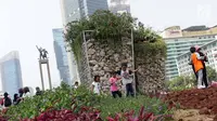 Anak-anak berjalan-jalan di area taman dekat Instalasi Gabion saat CFD di kawasan Bundaran Hotel Indonesia, Jakarta, Minggu (25/8/2019). Pengadaan Instalasi Gabion ini menggunakan Anggaran Pendapatan dan Belanja Daerah (APBD) Dinas Kehutanan DKI sebesar Rp 150 juta. (Liputan6.com/Helmi Fithriansyah)