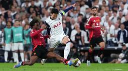 Pemain Tottenham Hotspur, Son Heung-min (tengah) berebut bola dengan pemain Manchester United, Patrick Dorgu dalam laga final Liga Europa 2024/2025 di Stadion San Mames, Bilbao, Spanyol, Kamis (22/05/2025) WIB. (AFP/Cesar Manso)