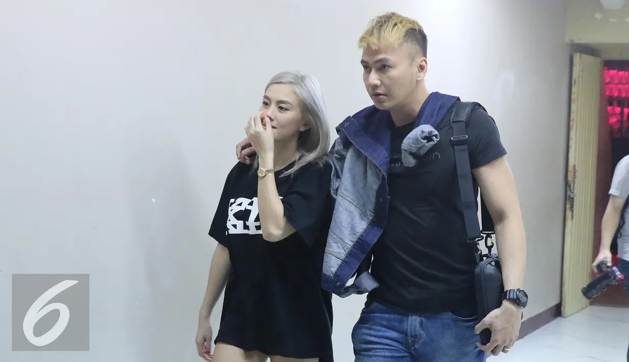 Agnes Mo berjalan bersama kekasihanya Wijaya Saputra di Istora Senayan, Jakarta, Senin (22/8). Agnez Mo akan tampil di HUT SCTV ke-26 yang akan disiarkan langsung pada Rabu (24/8). (Liputan6.com/Herman Zakharia)