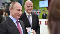 Presiden Rusia, Vladimir Putin memperlihatkan FAN ID untuk Piala Dunia FIFA 2018 di saksikan Presiden FIFA, Gianni Infantino di Sochi, Kamis (3/5). (Alexey NIKOLSKY/SPUTNIK/AFP)