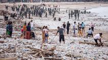 Para pekerja dan warga membersihkan ceceran dan tumpukan sampah plastik yang terdampar di Pantai Jimbaran, Bali, pada Selasa 10 Maret 2026. Pantai Jimbaran, Bali, kembali dipenuhi sampah kiriman. (Lana Priatna/AFP)