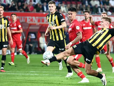 Pemain Twente, Mees Hilgers (tengah) berusaha mencetak gol ke gawang Vitesse dihalangi Gyan de Regt (kanan) pada laga lanjutan Liga Belanda 2023/2024 yang berlangsung di De Grolsch Veste Stadium, Enschede, Belanda, 27 September 2023. (AFP/Vincent Jannink)