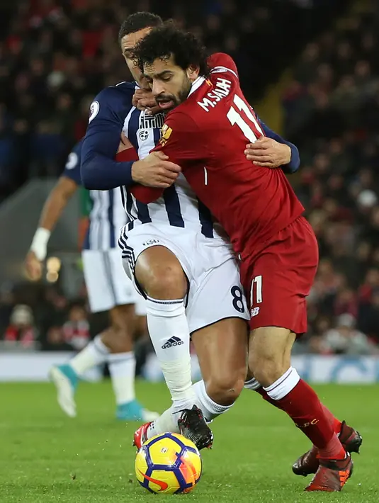 Pemain Liverpool, Mohamed Salah berebut bola dengan pemain West Bromwich Albion, Jake Livermore pada laga pekan ke-17 Premier League di Stadion Anfield, Rabu (13/12). Liverpool ditahan West Bromwich Albion tanpa gol. (Peter Byrne/PA via AP)