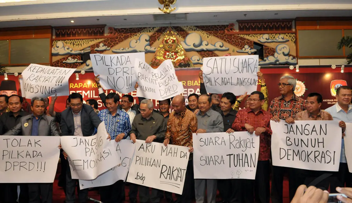 Para bupati dan walikota yang tergabung dalam Apkasi dan Apeksi membawa poster penolakan Pilkada melalui DPRD di Jakarta, (11/9/14). (Liputan6.com/Panji Diksana)
