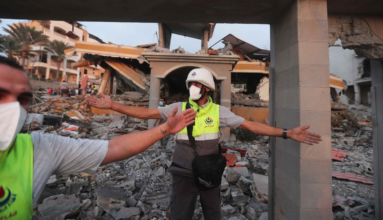 Militer Israel mengklaim serangan tersebut menargetkan infrastruktur dan posisi militer milik kelompok Hizbullah. Tampak dalam foto, anggota pertahanan sipil memblokir area di sekitar bangunan yang hancur akibat serangan udara Israel di desa Teir Debba, Lebanon Selatan, Kamis 6 November 2025. (AP Photo/Mohammad Zaatari)