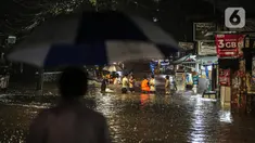 Sejumlah warga melintasi genangan banjir di kawasan Kemang, Jakarta, Selasa (4/10/2022). Jalan Kemang Utara IX tak bisa dilalui oleh kendaraan. Banjir menggenangi kawasan Pasar Kambing dan sejumlah rumah penduduk. (Liputan6.com/Faizal Fanani)