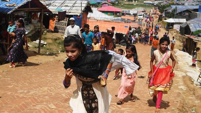 Bocah-bocah Rohingya mengenakan pakain baru selama perayaan Idul Adha di kamp pengungsi Thangkhali, Bangladesh, Rabu (22/8). Hampir setahun mereka menghuni kamp ini usai kabur menghindari represi militer di Negara Bagian Rakhine. (Dibyangshu SARKAR / AFP)