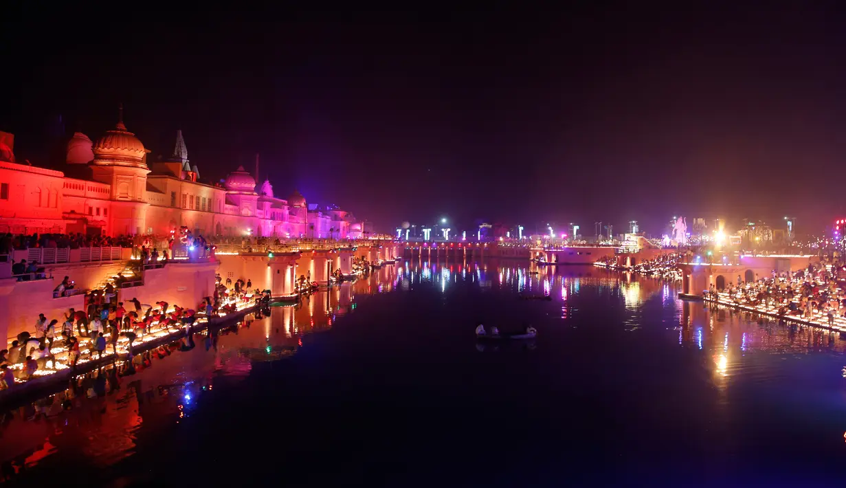 Cahaya lampu dari tanah liat menerangi tepi Sungai Sarayu sebagai bagian dari perayaan Diwali di Ayodhya, , Selasa (6/11). Kota di utara India itu memecahkan rekor dunia Guinness setelah menyalakan 300.150 lampu selama 45 menit. (AP/Rajesh Kumar Singh)