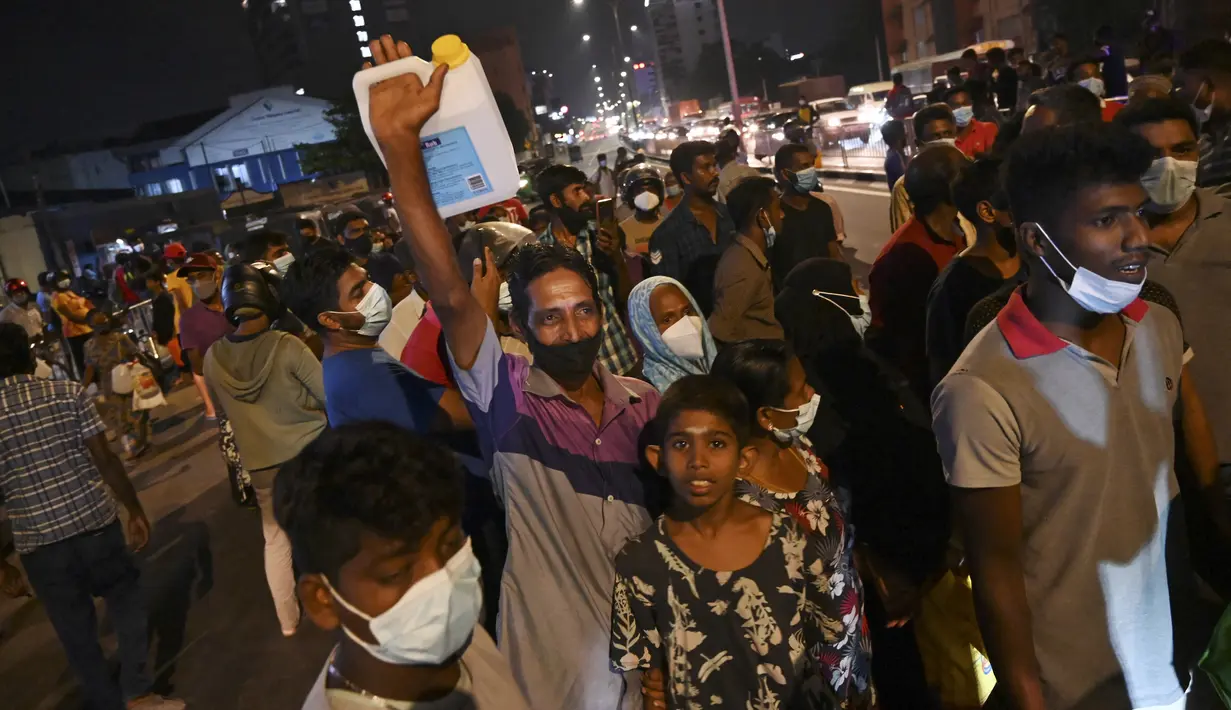 Warga berkumpul di pompa bensin untuk membeli minyak tanah di Kolombo (22/3/2022). Sri Lanka memerintahkan pasukan ke pompa bensin pada 22 Maret ketika protes sporadis meletus di antara ribuan pengendara yang mengantre setiap hari untuk mendapatkan bahan bakar yang langka. (AFP/Ishara S.Kodikara)