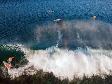 Pemandangan udara menunjukkan para peselancar menunggangi ombak di pantai Lhoknga, provinsi Aceh, pada Senin 12 Januari 2026. Indonesia merupakan negara kepulauan dengan kekayaan alamnya yang memukau. Salah satunya adalah Pantai Lhoknga di Kecamatan Lhoknga, Kabupaten Aceh Besar. (CHAIDEER MAHYUDDIN/AFP)