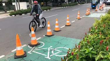 Pesepeda lewat di dekat jalur khusus sepeda, Blok M, Jakarta, Selasa (24/11/2020). Gubernur Anies Baswedan memperkirakan pembangunan jalur sepeda sepanjang 500 km di Ibu Kota bakal tertunda karena anggaran masih difokuskan untuk penanggulangan Covid-19 dan banjir. (Liputan6.com/Immanuel Antonius)