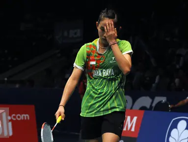 Pebulutangkis muda Indonesia dari klub Jaya Raya, Ruselli Hartawan mengusap keringat saat laga melawan Li Xuerui (Tiongkok) di BCA Indonesia Open di Istora Senayan Jakarta, Selasa (31/5).Ruselli kalah 21-16, 8-21. 11-21. (Liputan6.com/Helmi Fithriansyah)