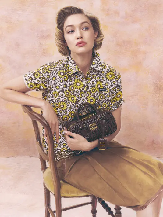 Padukan kemeja floral dan rok suede, Gigi Hadid jinjing tas Miu Miu dengan desain leather klasik [Miu Miu]