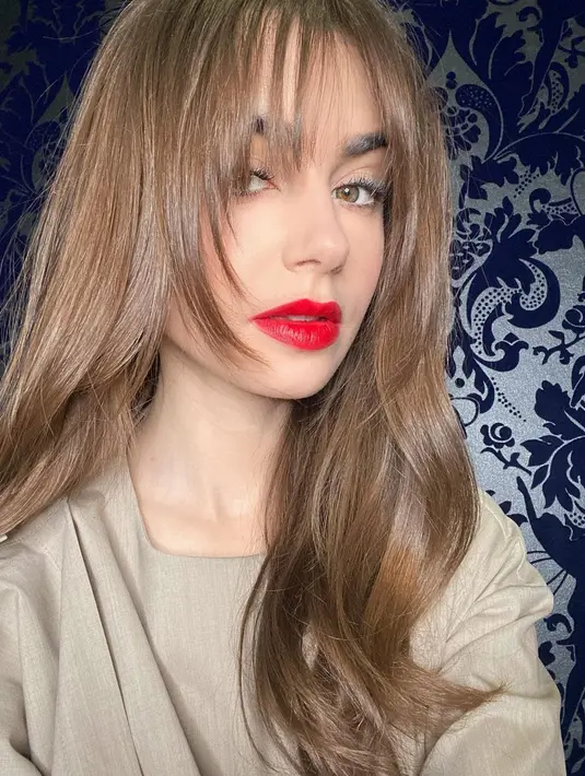 Penampilan Lily Collins sebagai gadis Prancis yang chic. Di sini, Lily Collins mengenakan warna merah yang cantik dan pas untuk kulitnya. Foto: Vogue.