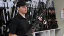 Penjaga toko senjata, Ryan Martinez  memegang senapan serbu AR-15 di toko senjata "Ready Gunner", Utah, AS, (21/6). Maraknya kasus penembakan seperti di Orlando baru terjadi, pemerintah AS akan menerapkan pengendalian senjata api. (REUTERS/George Frey)
