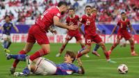 Striker Timnas Jepang, Ayase Ueda terjatuh usai dilanggar bek Indonesia, Jordi Amat di dalam kotak penalti pada laga ketiga Grup D Piala Asia 2024 di Al-Thumama Stadium, Doha, Qatar, Rabu (24/1/2024) malam WIB. (AFP/Giuseppe Cacace)