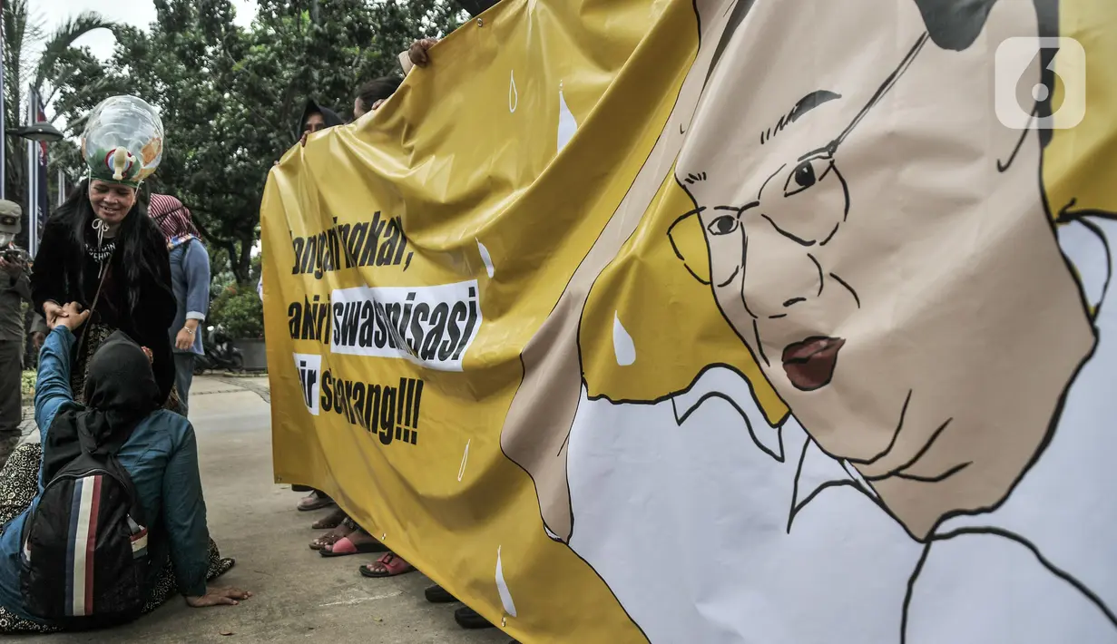 Massa Koalisi Masyarakat Menolak Swastanisasi Air Jakarta (KMMSAJ) melakukan aksi teatrikal di depan Balai Kota, Jakarta Pusat, Selasa (22/3/2022). Mereka menuntut Anies Baswedan menjamin pemulihan hak bagi masyarakat miskin yang terdampak swastanisasi air. (merdeka.com/Iqbal S Nugroho)