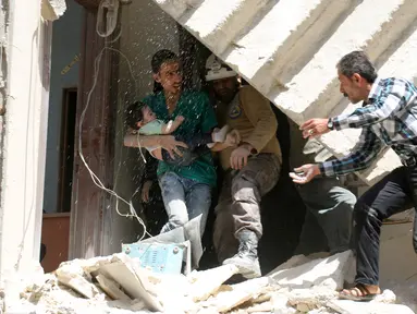 Relawan berusaha mengevakuasi bayi dari sebuah bangunan runtuh setelah serangan udara di wilayah yang dikuasai pemberontak al-Kalasa di kota Suriah bagian utara, Aleppo, Kamis (28/4). (AFP PHOTO / Ameer ALHALBI)