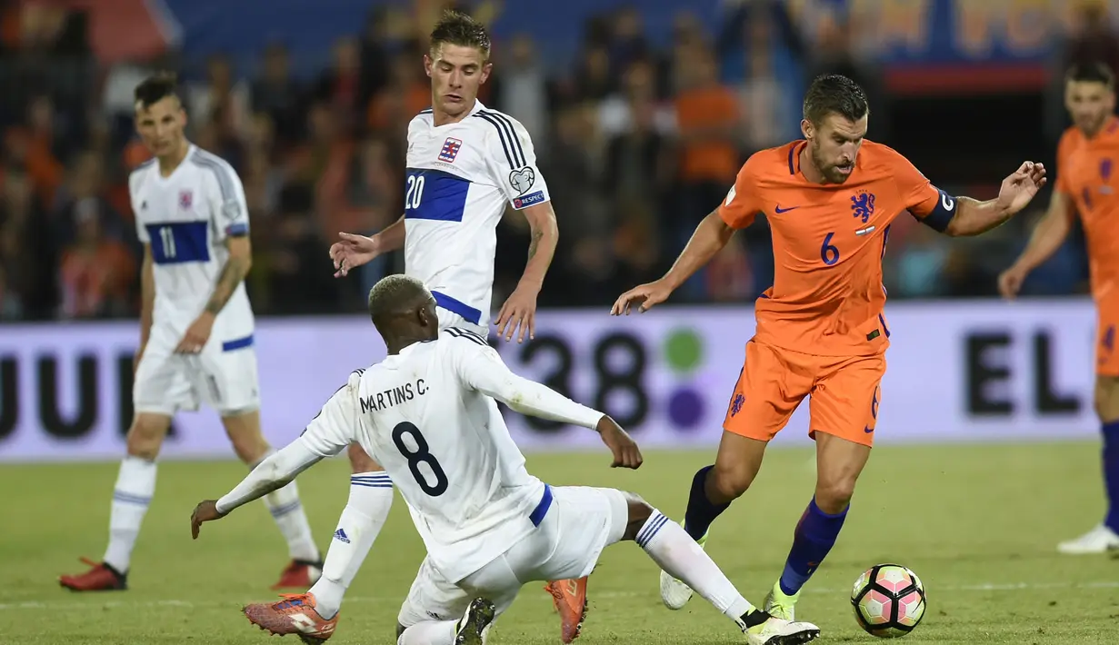 Aksi pemain Belanda, Kevin Strootman (kanan) melewati adangan pemain Luksemburg pada Kualiifikasi Piala Dunia 2018 di Rotterdam. (AFP/ John Thys)