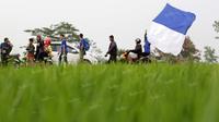 Belasan bobotoh berjalan melintasi sawah menyaksikan tim kesayangan Persib berlaga di Stadion Si Jalak Harupat, Soreang, Bandung, Rabu (30/3/2016). Perjuangan terbayar sukses Persib melaju ke final Torabika Bhayangkara Cup. (Bola.com/Nicklas Hanoatubun)