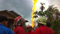 Petugas pemadam kebakaran berada di lokasi kebakaran pengeboran sumur minyak ilegal milik warga di Peureulak, Provinsi Aceh, Rabu (25/4). Ledakan diduga terjadi saat berlangsungnya penggalian untuk menyedot minyak mentah dari perut bumi (ILYAS ISMAIL/AFP)
