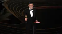 Rami Malek menerima penghargaan di atas panggung perhelatan Oscar 2019 di Dolby Theatre, Los Angeles, Minggu (24/2). Rami Malek meraih piala Oscar 2019 sebagai Aktor Pemeran Utama Terbaik dalam film Bohemian Rhapsody. Chris Pizzello/Invision/AP)