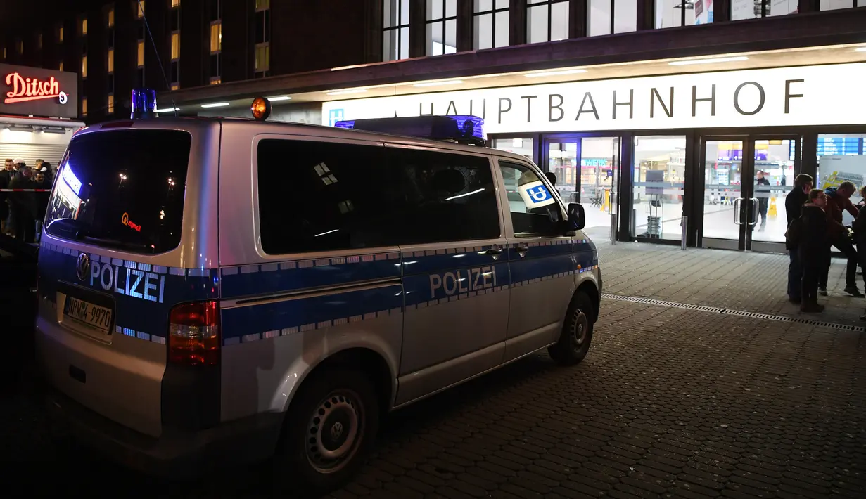 Kendaraan polisi terparkir di sekitar sebuah stasiun di Dusseldorf, Jerman, setelah serangan kapak yang dilakukan seorang pria, Kamis (9/3). Meski serangan dilakukan satu orang, namun aparat keamanan setempat menangkap dua tersangka. (Patrik STOLLARZ/AFP)