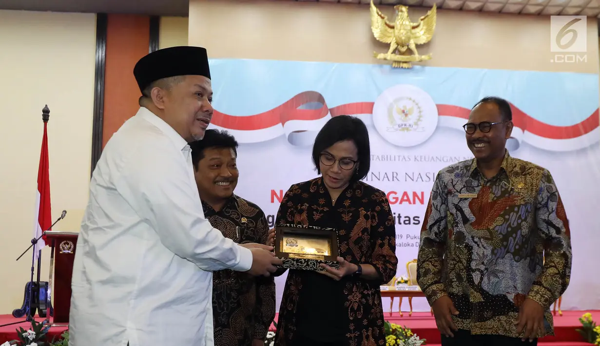 Wakil Ketua DPR Fahri Hamzah memberikan cinderamata kepada Menteri Keuangan Sri Mulyani dalam Seminar Nasional Nota Keuangan RAPBN 2020 : Mengawal Akuntabilitas Penerimaan Negara di Kompleks Parlemen MPR/DPR-DPD, Senayan, Jakarta, Rabu (21/8/2019). (Liputan6.com/Johan Tallo)
